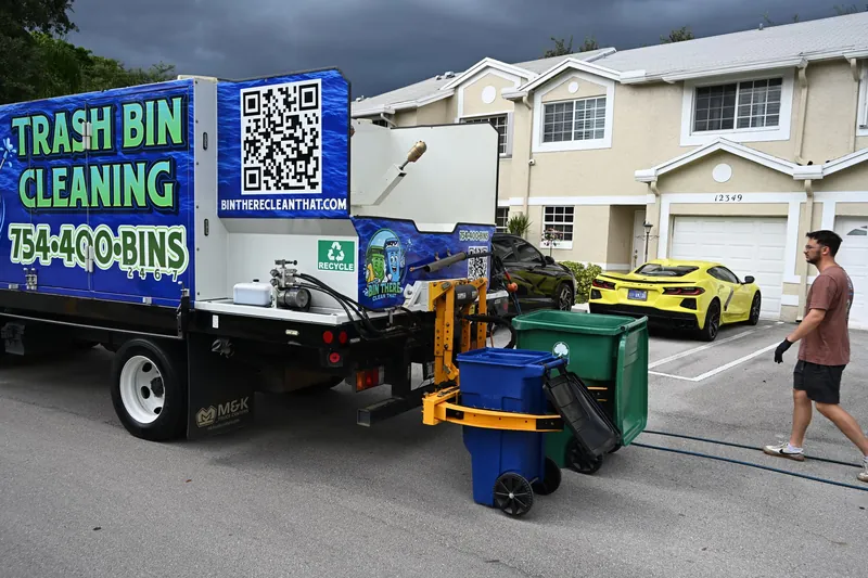 Bin cleaning truck at a curb in a townhome community